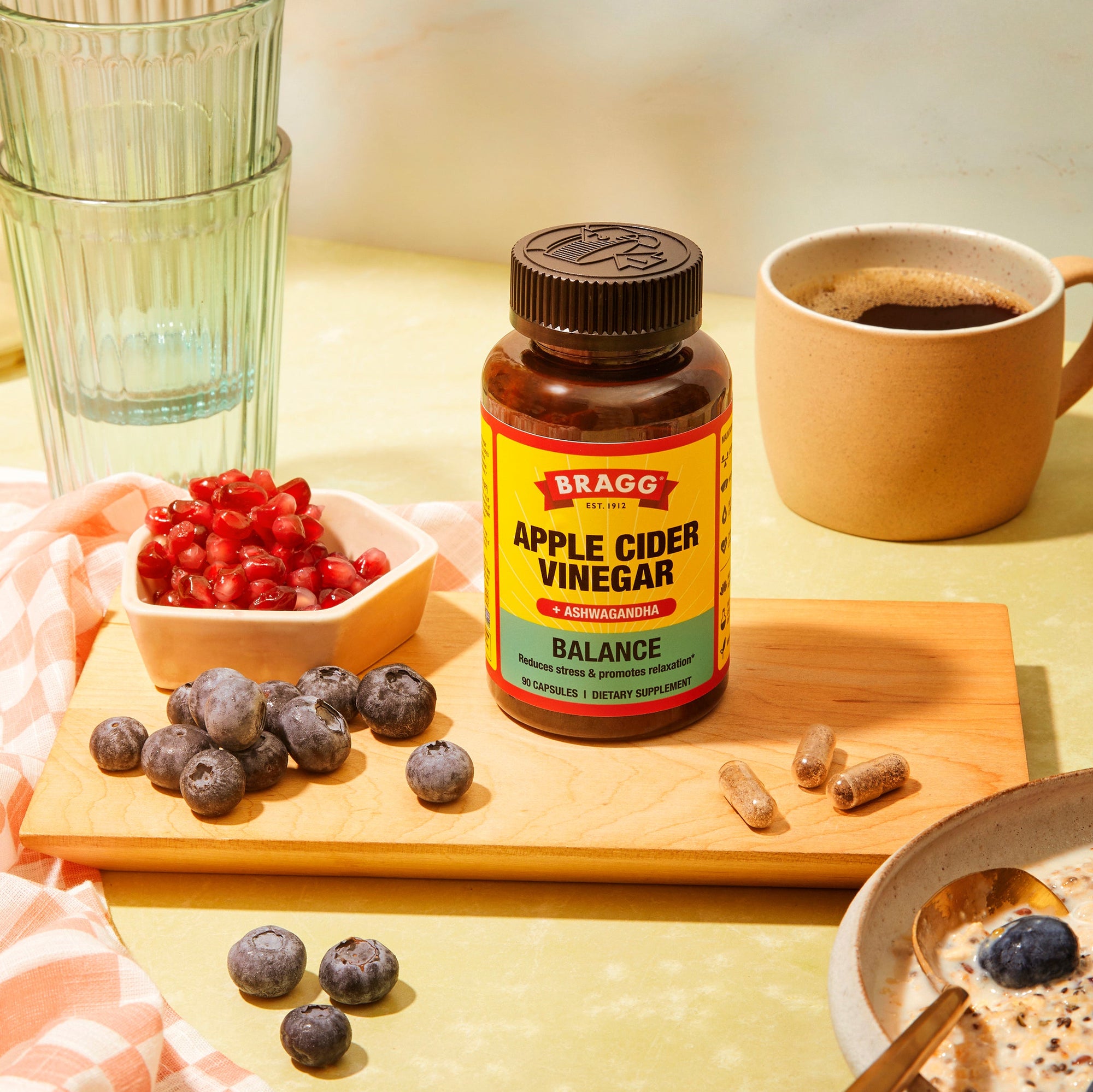 Bottle of Apple Cider Vinegar supplement on a table next to berries 