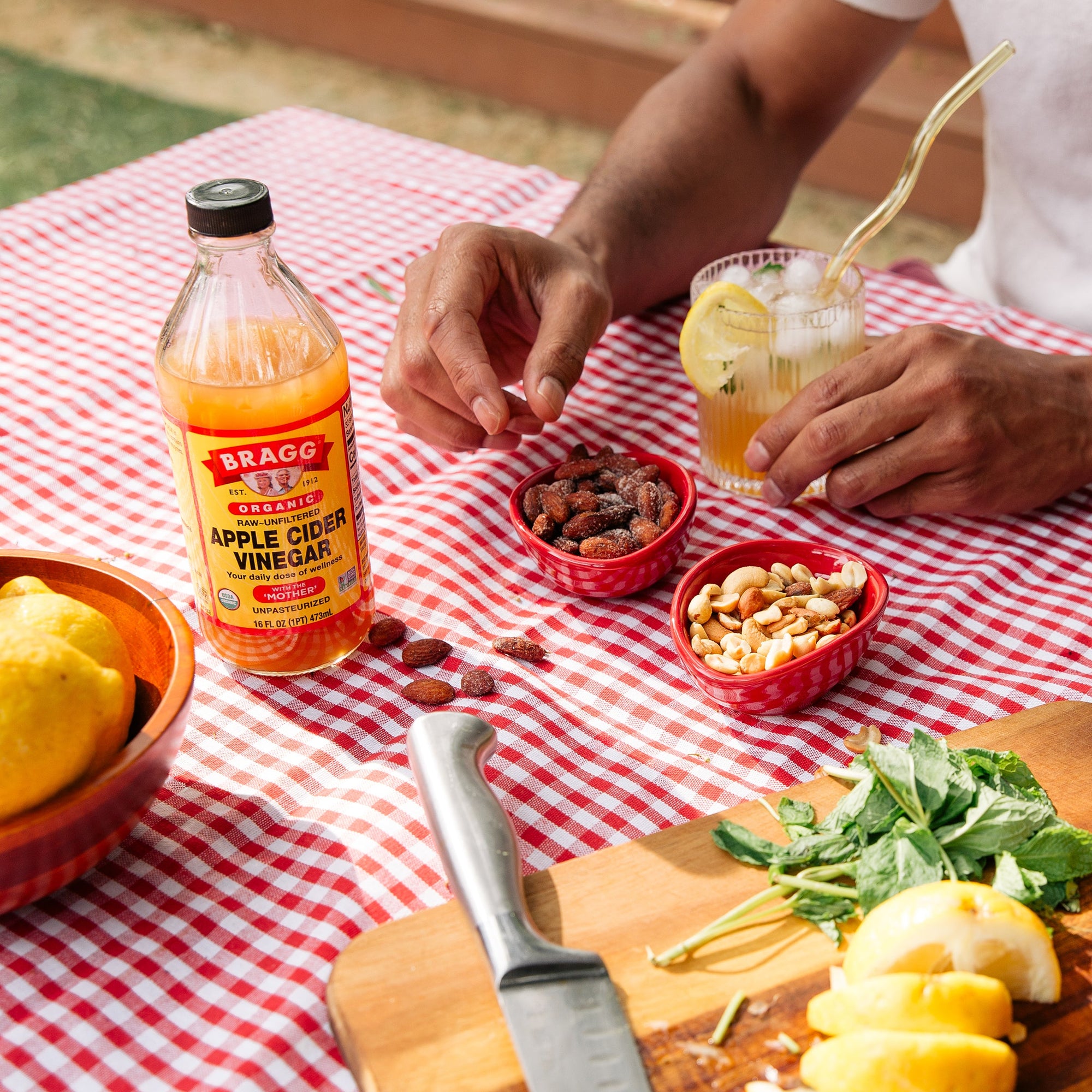 Bottle of Apple Cider Vinegar on a table with various nuts and seeds 