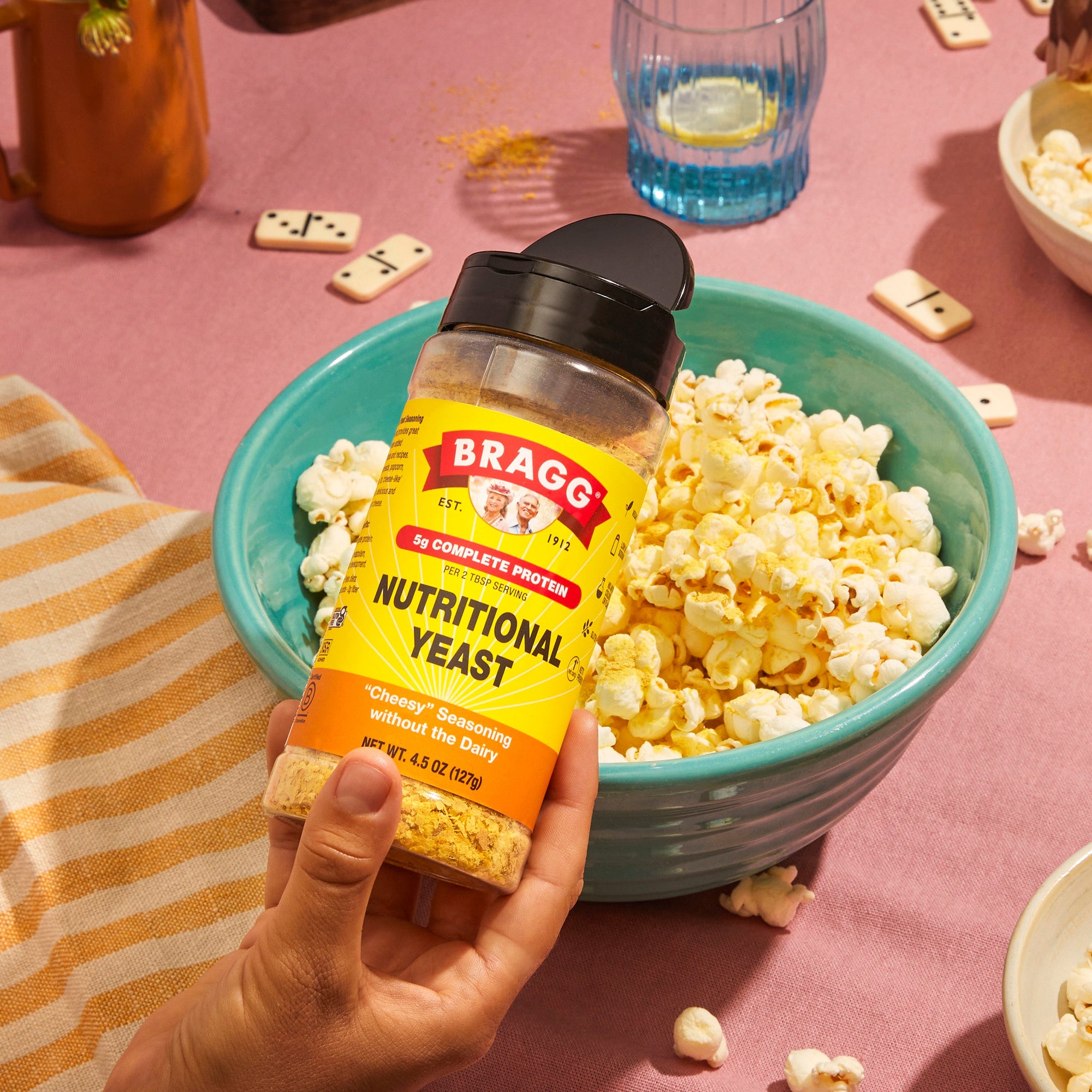 Nutritional Yeast being sprinkled on a bowl of popcorn